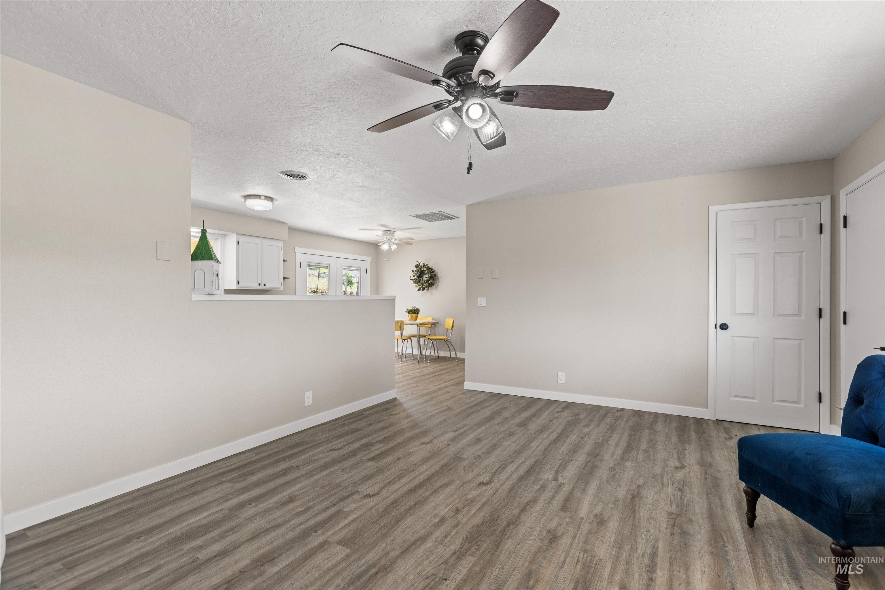 12184 Hill Road Payette, ID 83661 - Photo 11 of 35 Expansive living space featuring wood-finish flooring, neutral wall tones, and a ceiling fan with integrated lighting