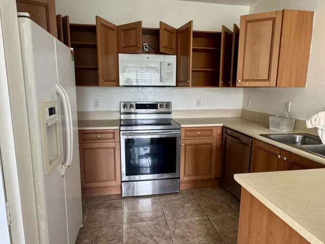 a kitchen with stainless steel appliances granite countertop a refrigerator stove and sink