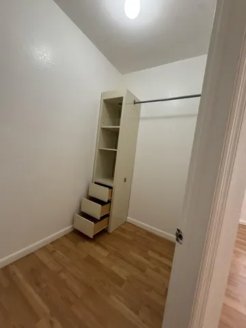 an empty room with wooden floor and white walls