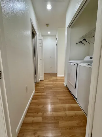 a view of a hallway with wooden floor and staircase