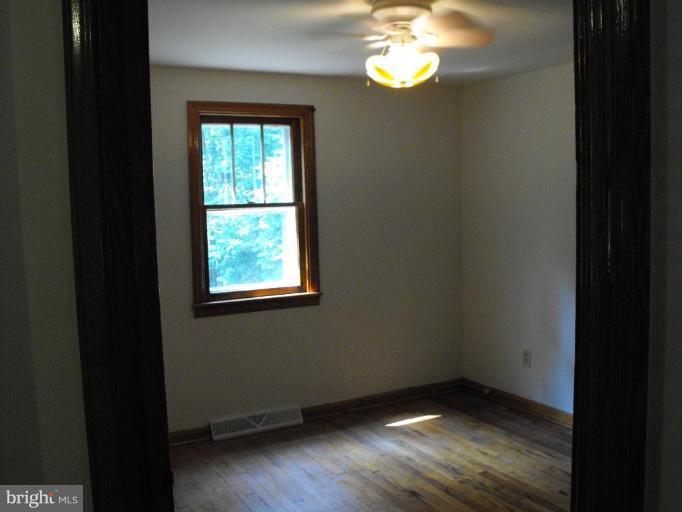 116 Paw Paw Road North Bloomery, WV 26817 - Photo 9 of 16 a view of an empty room with wooden floor and a window