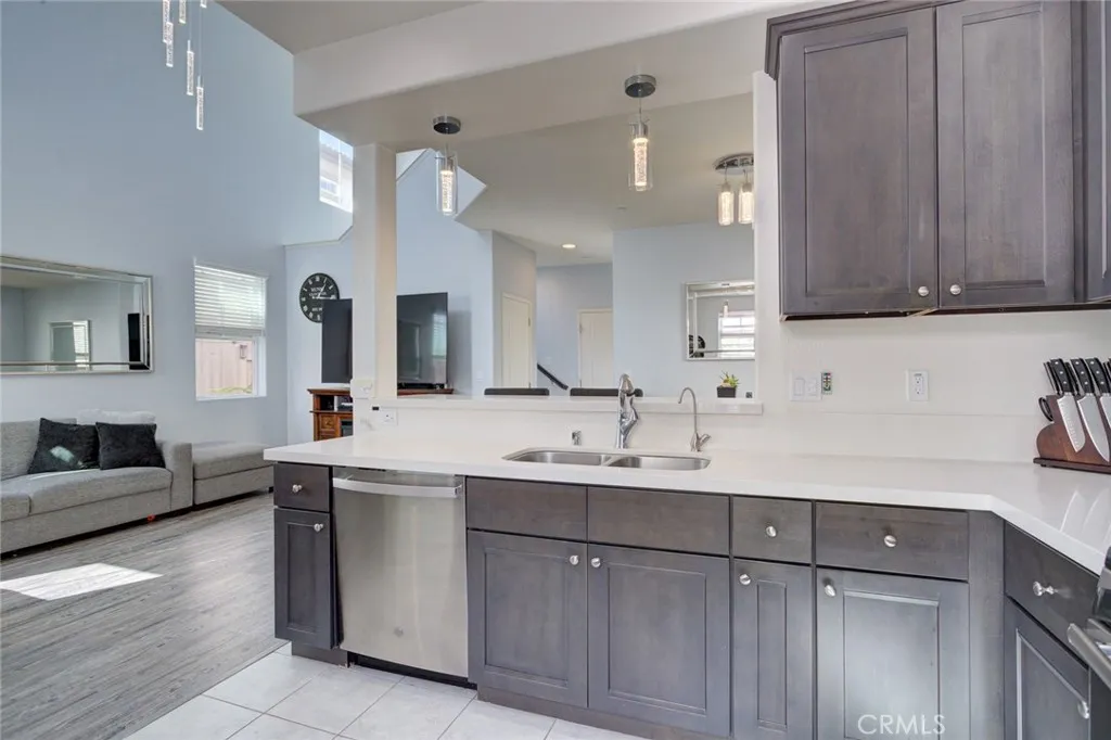 1913 Celebration Avenue Santa Maria, CA 93454 - Photo 17 of 35 a kitchen with a sink dishwasher a stove and a refrigerator with wooden cabinets
