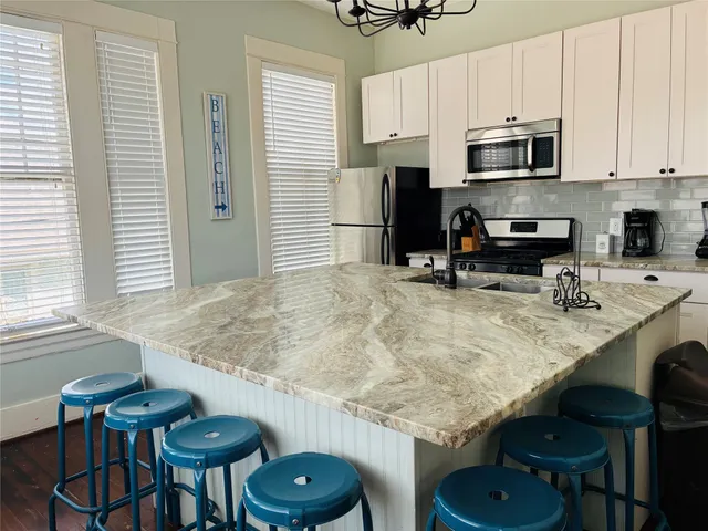 a kitchen with granite countertop a sink appliances and cabinets