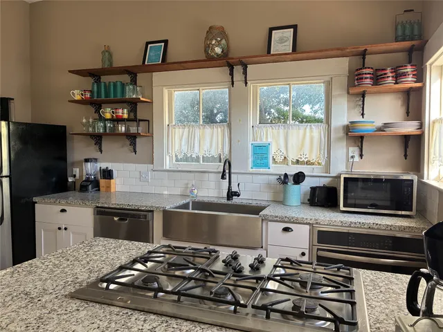 a kitchen with stainless steel appliances a stove a sink and a refrigerator