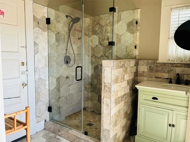 a bathroom with a shower and a sink