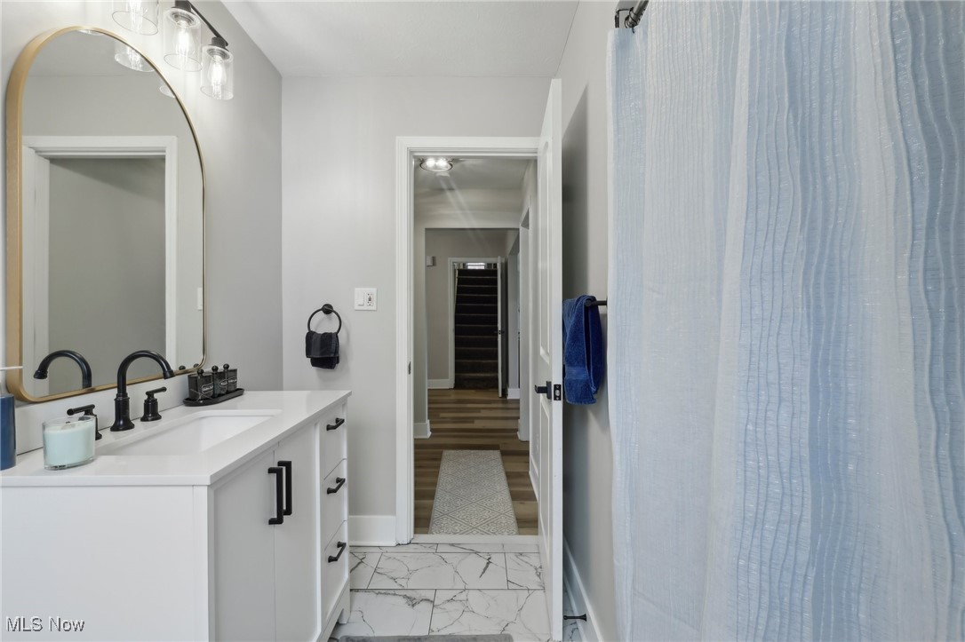 21750 Brookpark Road Cleveland, OH 44126 - Photo 16 of 30 Bathroom featuring baseboards, marble finish floor, and vanity