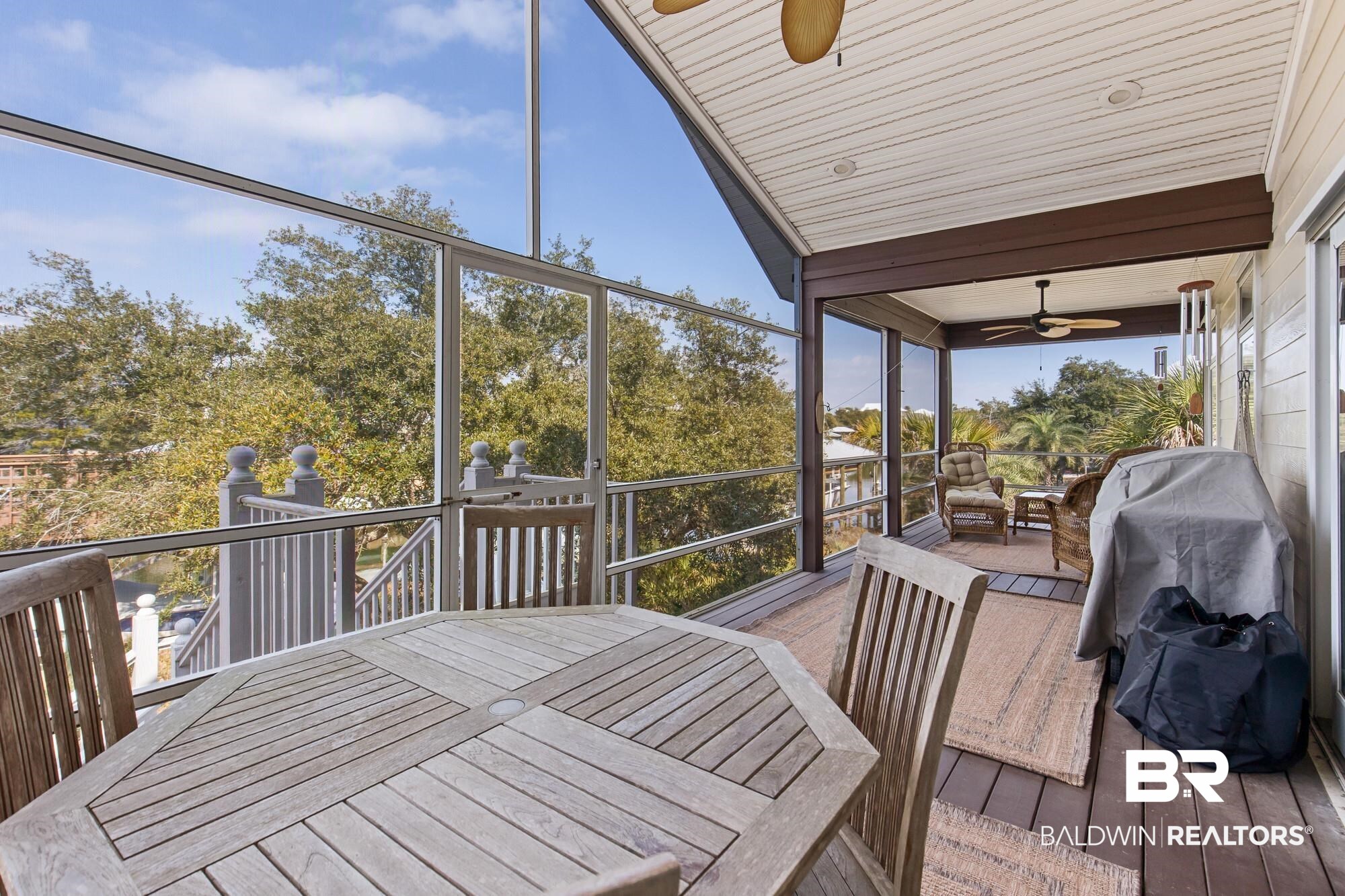 32191 River Road Orange Beach, AL 36561 - Photo 24 of 46 Sunroom / solarium with outdoor dining space, a ceiling fan, and a wooden deck