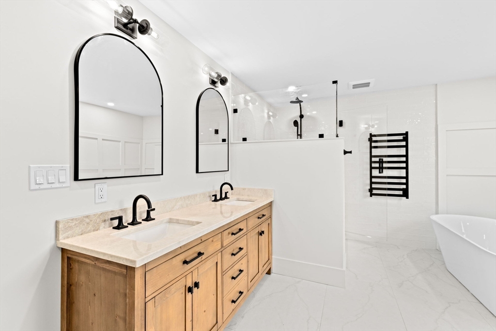 7 Lewis Court Hingham, MA 02043 - Photo 29 of 42 a bathroom with a double vanity sink a mirror a bathtub and shower