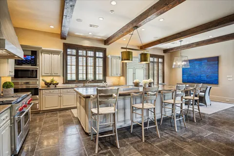 a large dining space with furniture a kitchen and chandelier