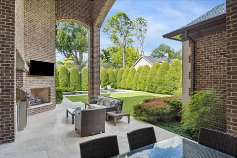 a view of a patio with couches table and chairs and potted plants
