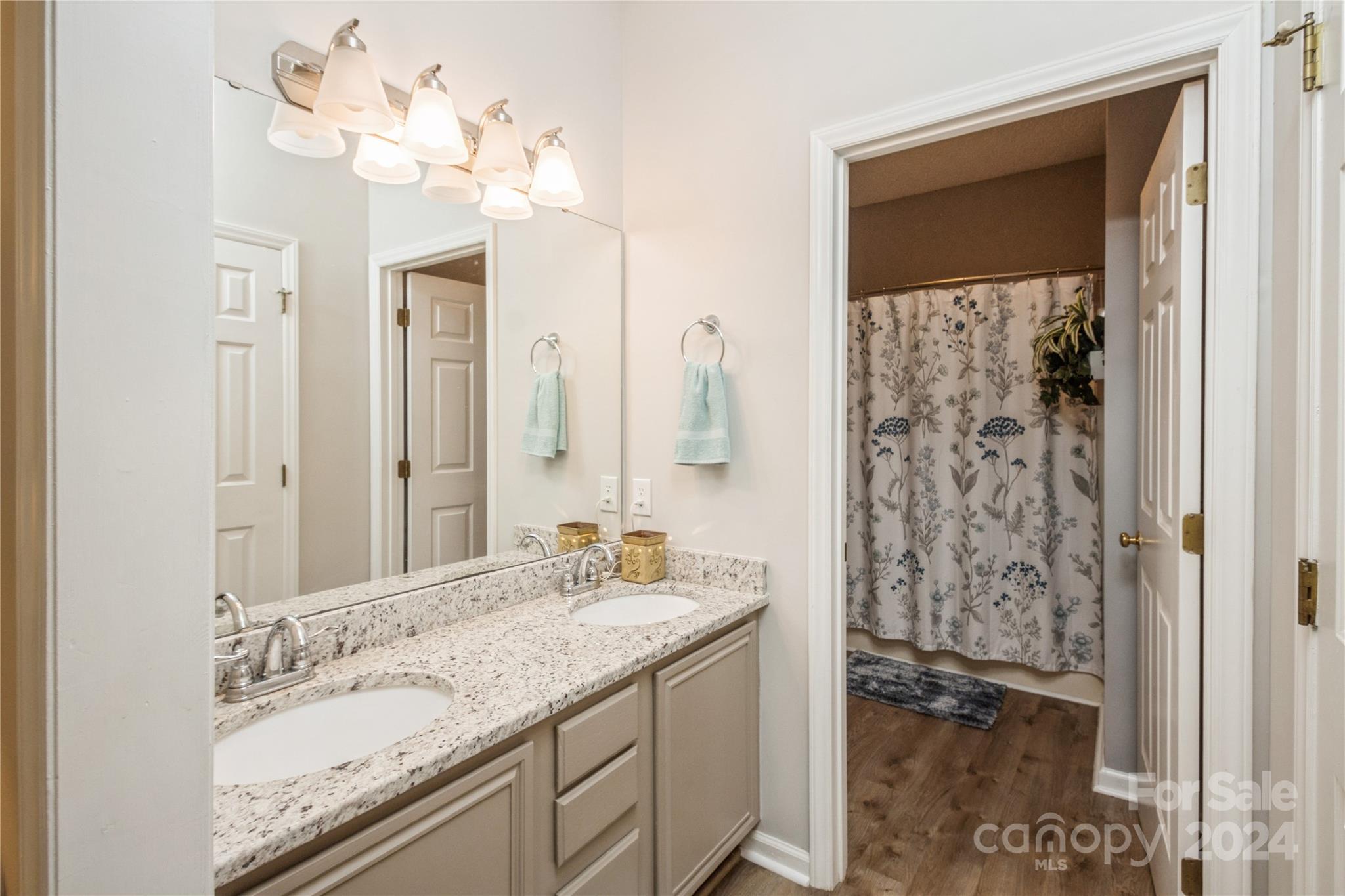19960 Oak Leaf Circle Cornelius, NC 28031 - Photo 25 of 35 a bathroom with a granite countertop sink a mirror and a shower