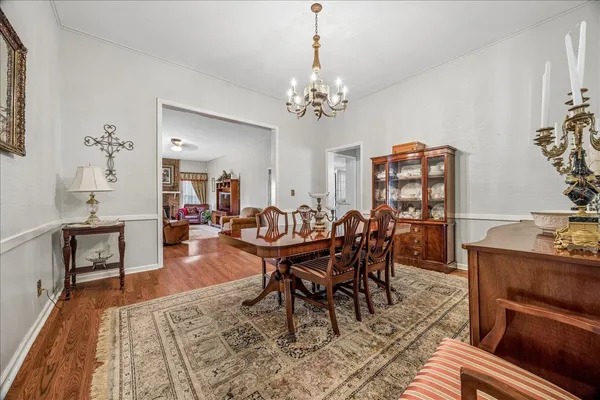 a dining room with furniture a chandelier and wooden floor
