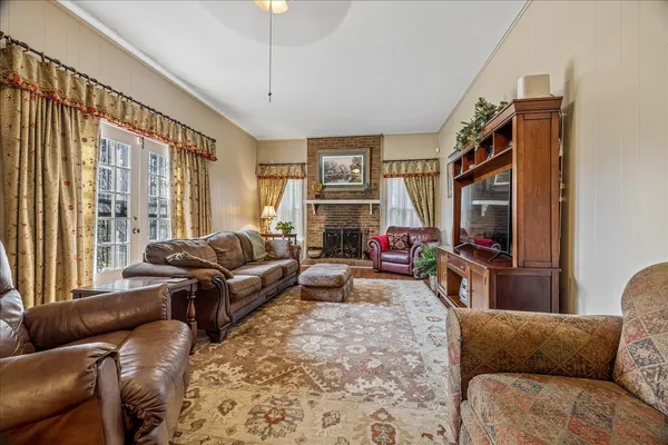 a living room with furniture a flat screen tv and a large window
