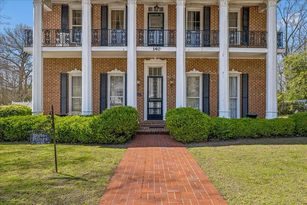 a view of brick house with a yard