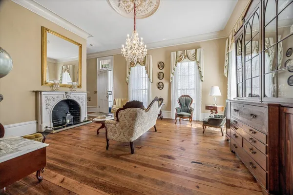 a living room with furniture a fireplace and a chandelier