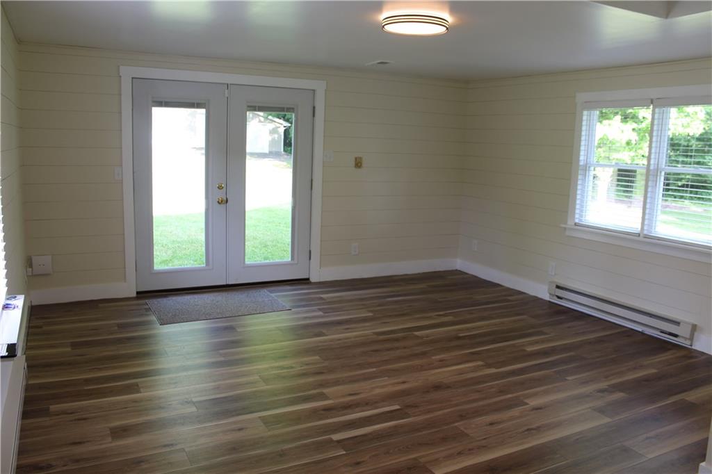354 Airport Road Mercer, PA 16137 - Photo 4 of 25 an empty room with wooden floor and windows