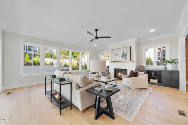 a living room with furniture a fireplace and a large window