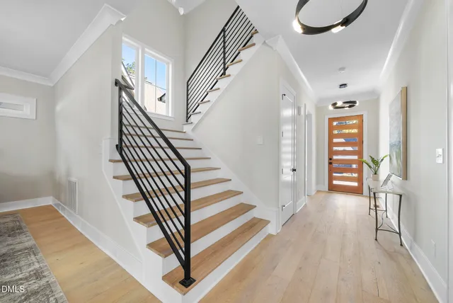 a view of a hallway with wooden floor and staircase