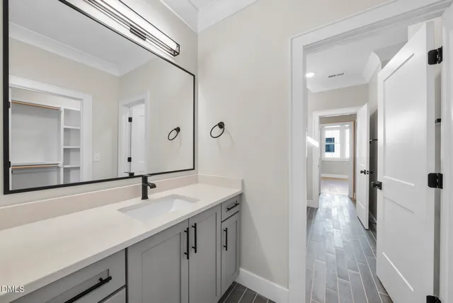 a bathroom with a granite countertop sink toilet and mirror