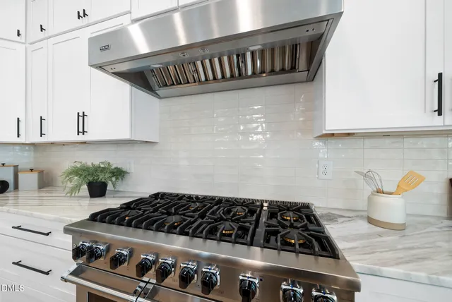 a kitchen with granite countertop a stove and cabinets