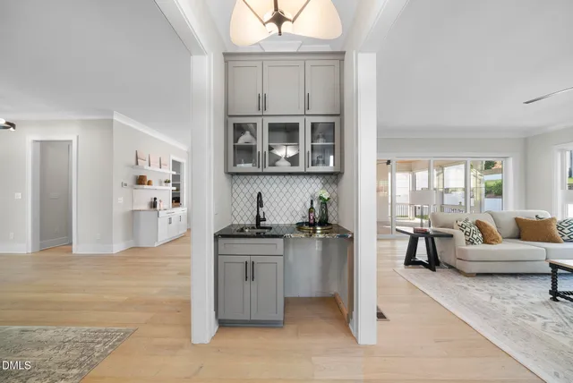 a kitchen with stainless steel appliances granite countertop a stove top oven a sink a dining table and chairs with wooden floor