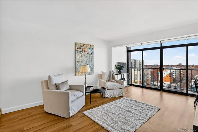 a living room with furniture wooden floor and a large window
