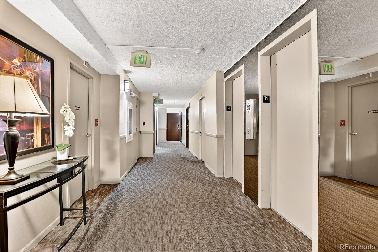 2 Adams Street, Unit 1401 Denver, CO 80206 - Photo 15 of 21 a view of a hallway view with wooden floor and staircase