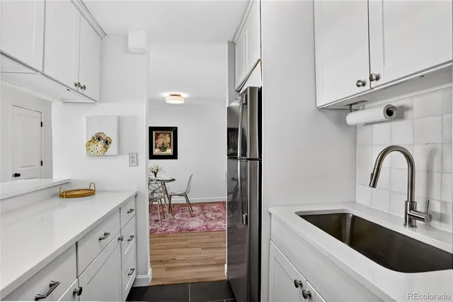 a kitchen with stainless steel appliances kitchen island a white counter top and a sink