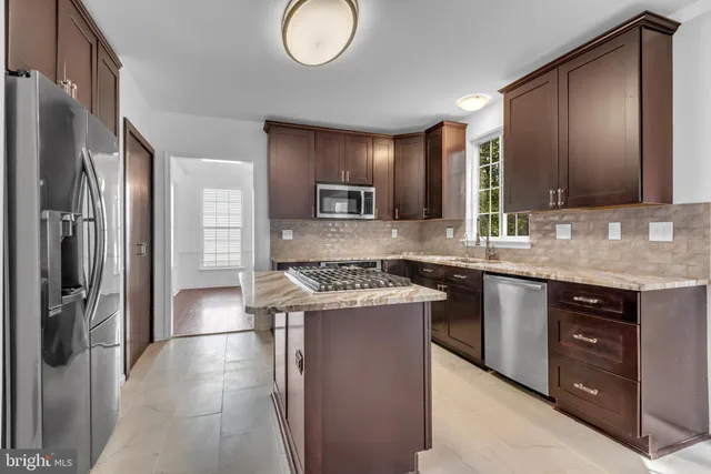 a kitchen with stainless steel appliances granite countertop a stove and a refrigerator