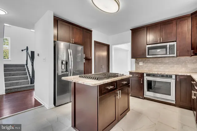 a large kitchen with kitchen island granite countertop a large window and a sink