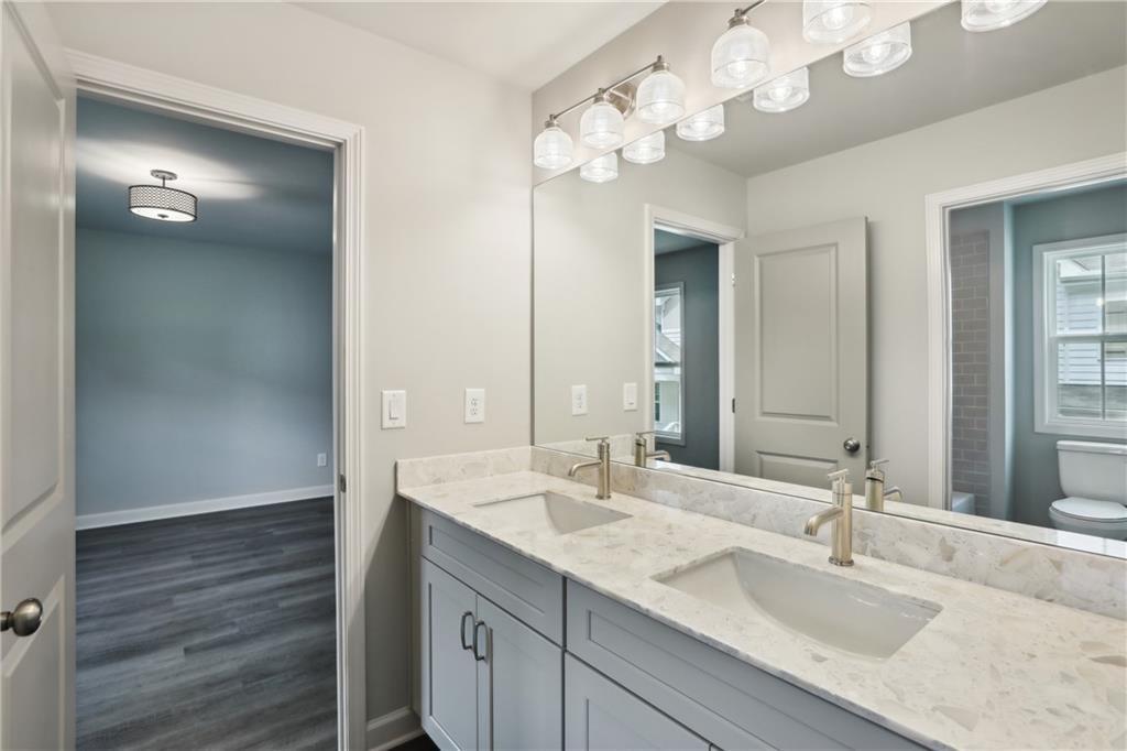 911 East Green Lane Clarkston, GA 30021 - Photo 23 of 43 a bathroom with a granite countertop sink a light fixture and a mirror