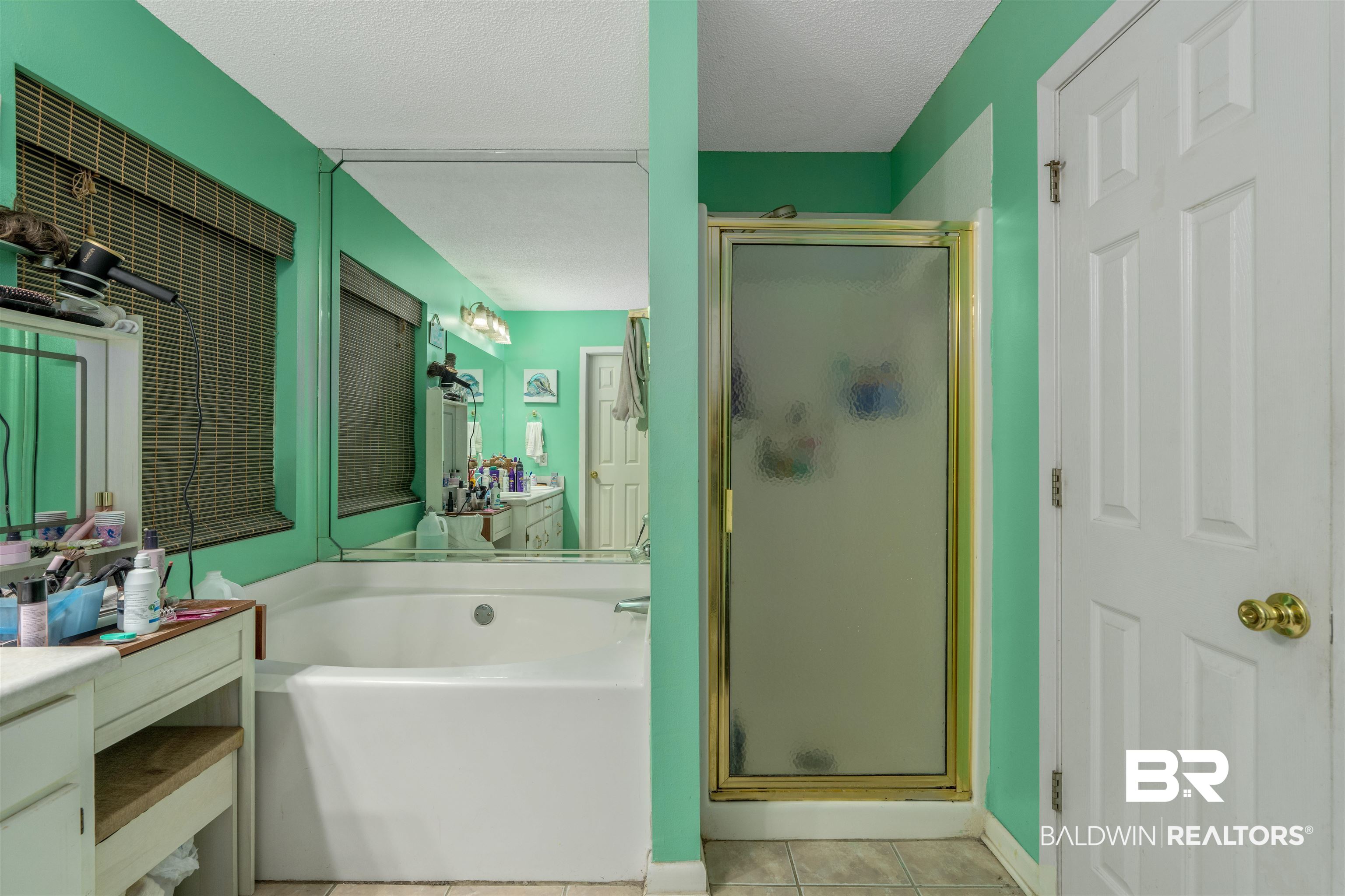 23186 Pecan Street Robertsdale, AL 36567 - Photo 13 of 36 Full bath with light tile patterned floors, a stall shower, a garden tub, a textured ceiling, and vanity