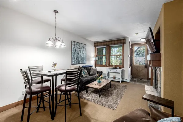a living room with furniture chandelier and a flat screen tv