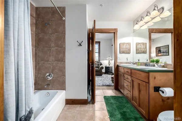 a bathroom with a tub a sink a mirror and a shower