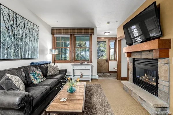 a living room with furniture a flat screen tv and a fireplace