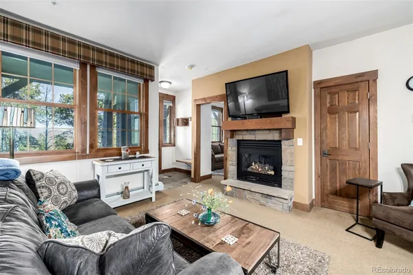a living room with furniture a flat screen tv and a fireplace