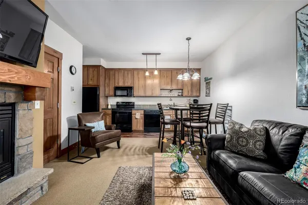 a living room with stainless steel appliances furniture and a kitchen view