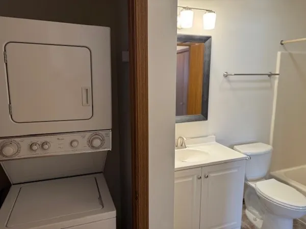 a bathroom with a toilet sink vanity and mirror
