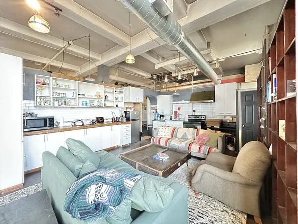 a living room with furniture and a view of kitchen