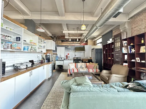 a living room with lots of furniture and kitchen view
