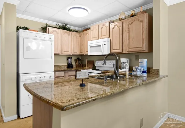 a kitchen with stainless steel appliances granite countertop a sink a refrigerator and a counter space