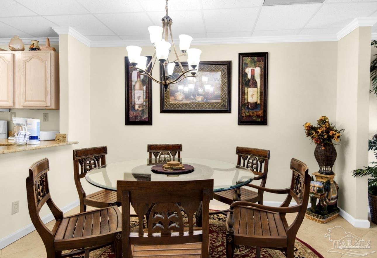 999 Fort Pickens Road, Unit 506 Pensacola Beach, FL 32561 - Photo 4 of 8 a view of a dining room with furniture a chandelier and wooden floor
