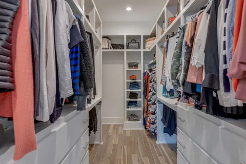 a view of walk in closet with clothes and shoes