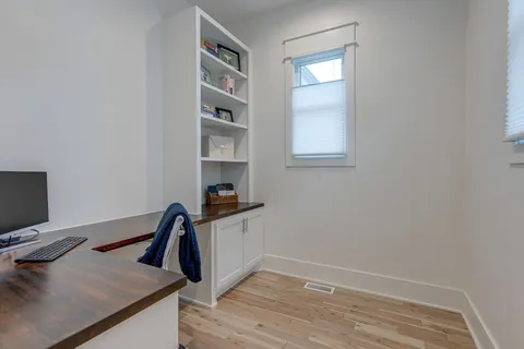 a view of a workspace with furniture and wooden floor