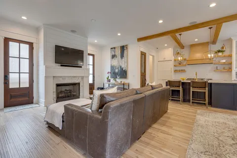 a large living room with stainless steel appliances granite countertop couches a fireplace and a kitchen island
