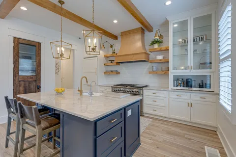 a kitchen with a sink a stove cabinets and wooden floor