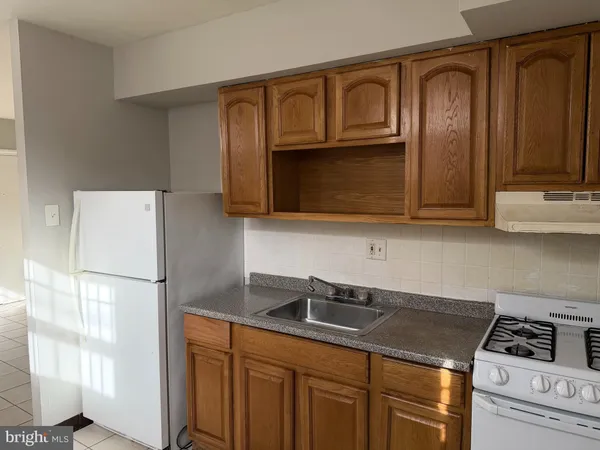 a kitchen with a refrigerator a stove and cabinets