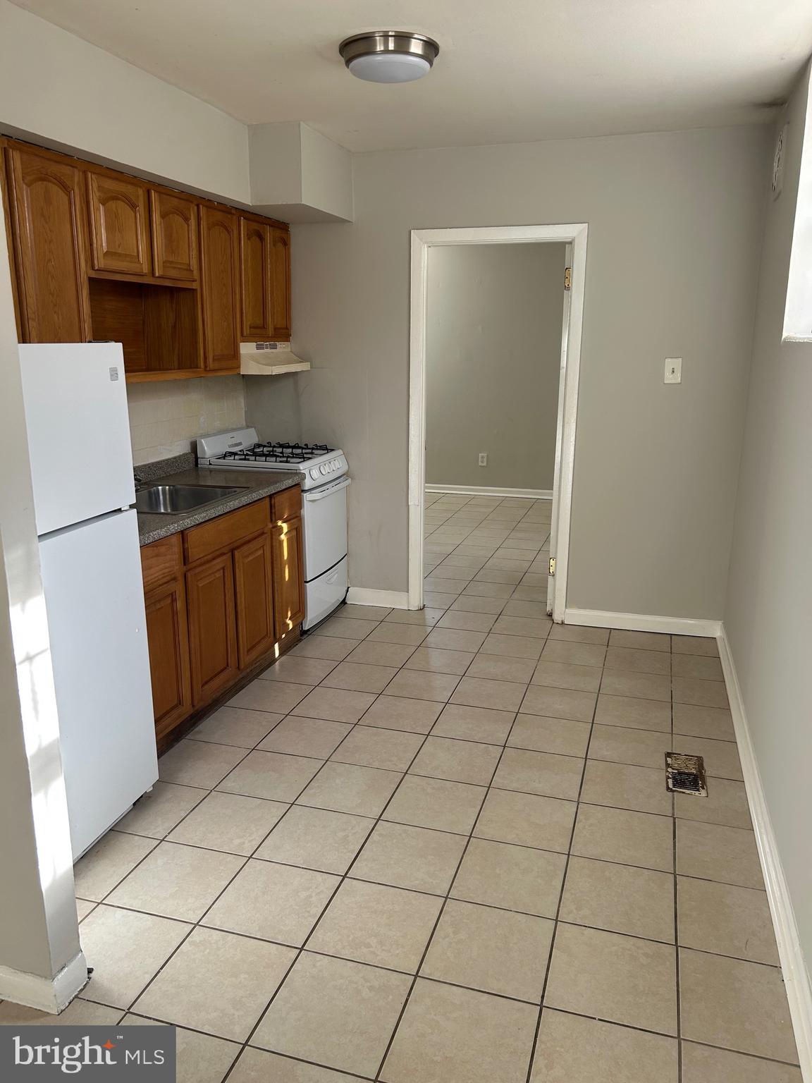 5711 Erdrick Street, Unit 3 Philadelphia, PA 19135 - Photo 9 of 18 a kitchen with stainless steel appliances a refrigerator sink and cabinets