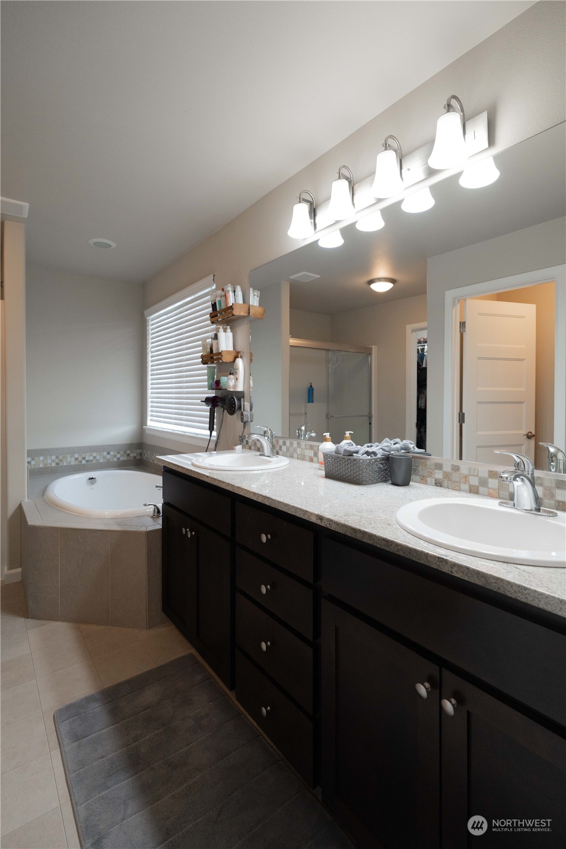 4731 Rosa Court Lacey, WA 98503 - Photo 20 of 31 a bathroom with a tub double vanity sink and a large mirror