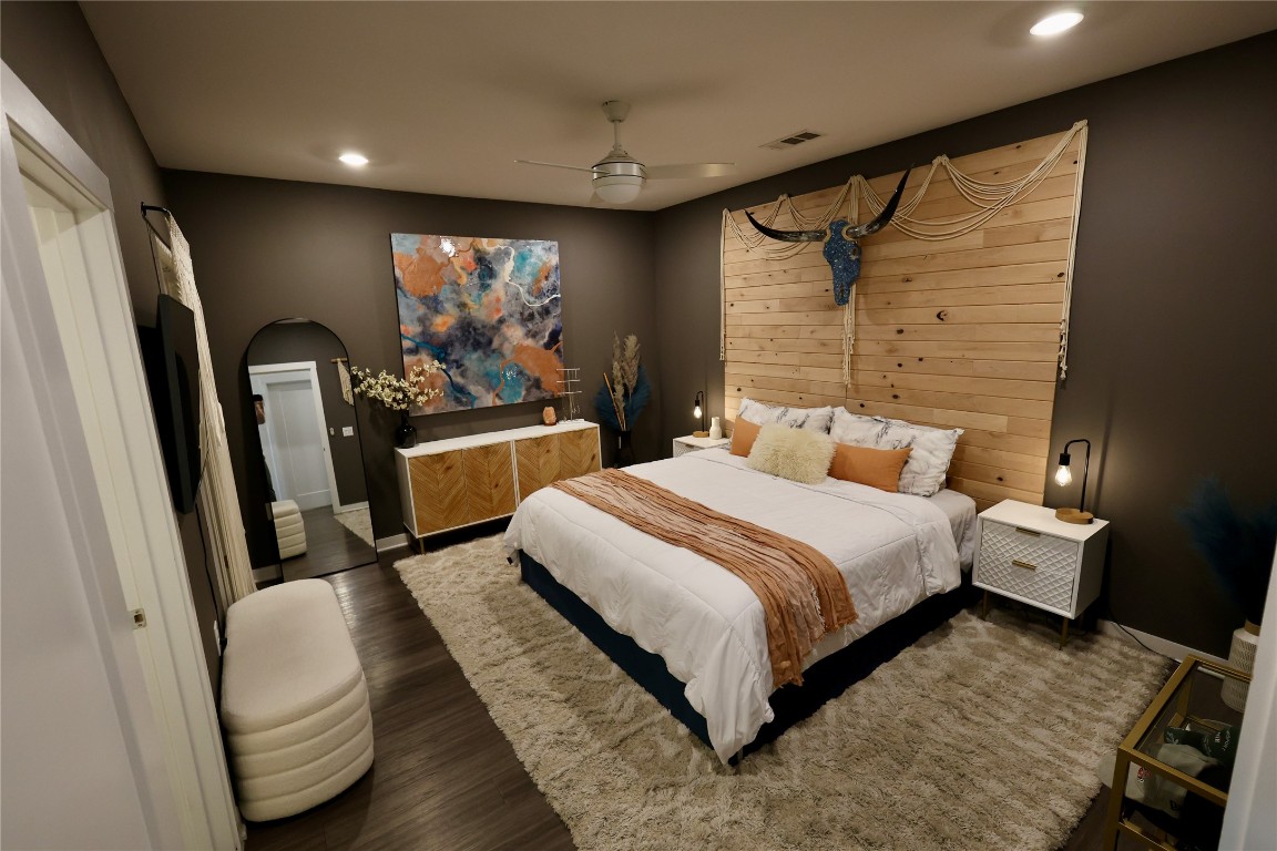a bedroom with a bed and dresser with mirror